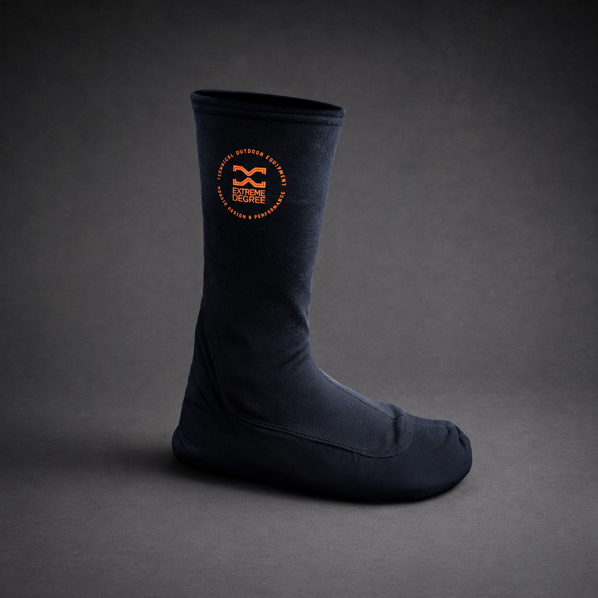 A single dark navy blue sock with a circular orange logo on the upper calf, displayed on a dark gray studio background.